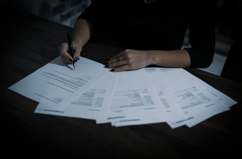 Woman reviewing and signing paperwork at a table